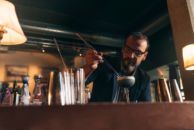 Foto il barman esperto sta preparando un cocktail al night club.