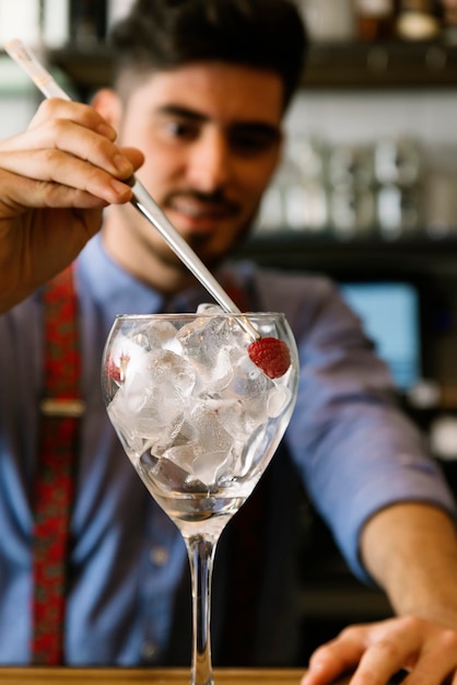 Expert barman is making cocktail at night club