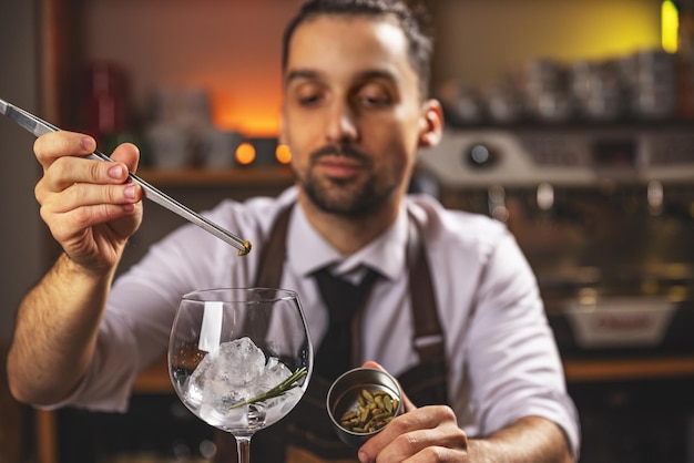 Expert barman is making cocktail