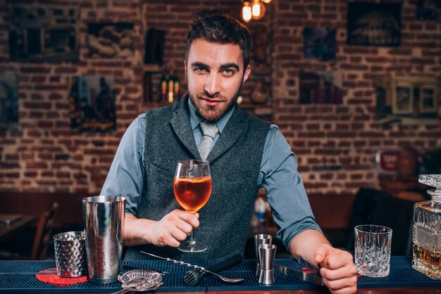 Foto esperto barista che presenta un drink d'autore al bar o al ristorante del pub locale