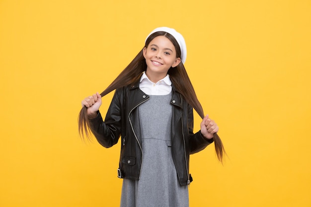 Expert care for every haircare need. School age kid hold long hair. Hair salon. Girl child yellow background. Be great every day.