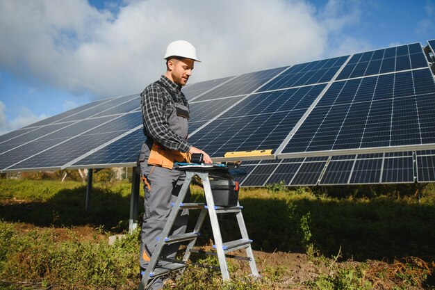 Expert is inspecting quality of a solar batterys worker in\
uniform and helmet with equipment ecology power conservation\
concept