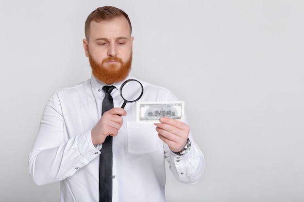 Expert looking at magnifying glass for bill