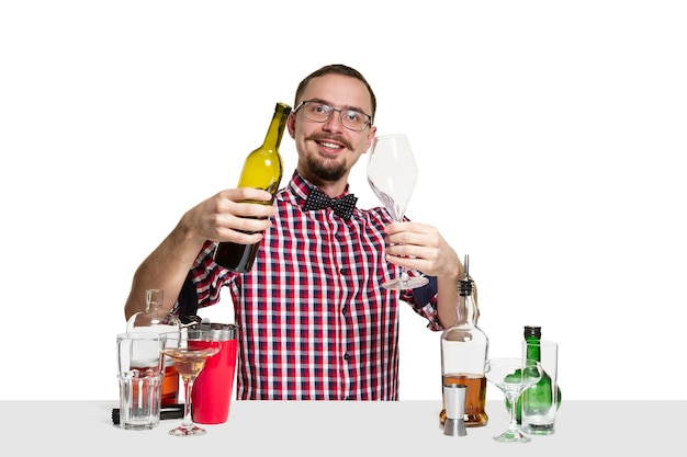 Expert male barman is making cocktail  isolated on white wall. International barman day, bar, alcohol, restaurant, party, pub, nightlife, cocktail, nightclub concept