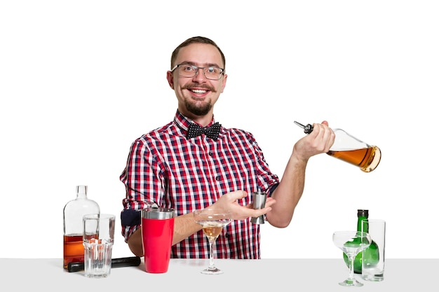 Expert male barman is making cocktail at studio isolated on white wall