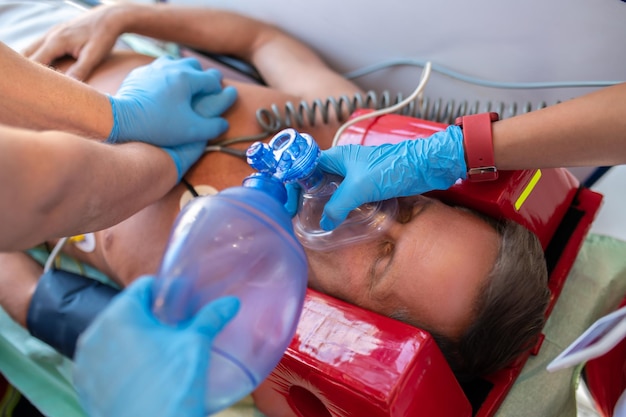 Foto esperti paramedici che eseguono la rianimazione cardiopolmonare sull'uomo privo di sensi