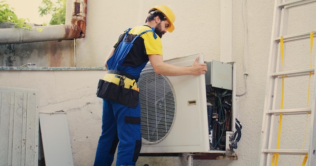 Expert wireman works on air conditioner