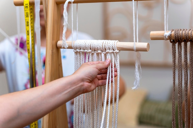 Expertise in textielontwerp Vrouw die handgemaakte meesterwerken van macrame maakt