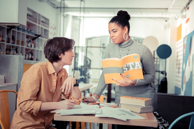 Explaining. The female student helping her male colleague to prepare for the exam