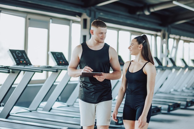 Photo explaining workout techniques personal trainer engages in a dialogue with a female client