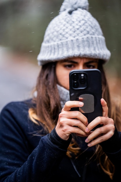 Photo explorer adjusts hat and gloves in snowcovered woodland embracing winter exploration