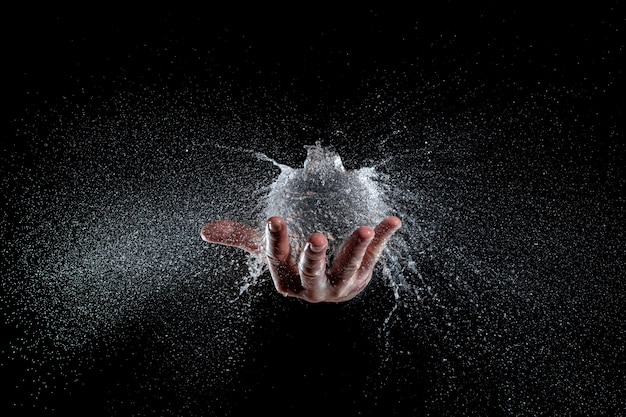 Explosion of a balloon full of water held on a hand