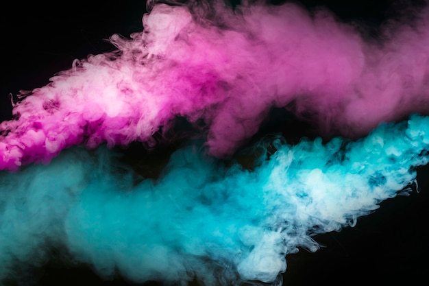 Foto esplosione di fumo blu e rosa su sfondo nero