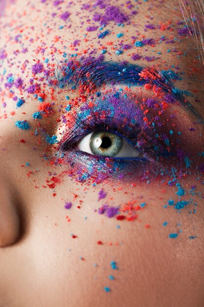 Explosion of color, multi-colored shadows scattered on the eyelids. Colored Smokey eyes and blue eyebrows.