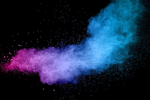 Explosion of color powder on black background. Splash of color powder dust on dark background