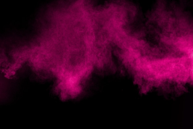 Explosion of pink color powder on black background