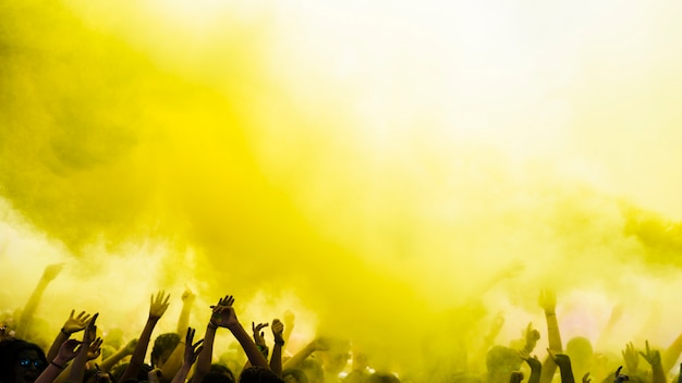 Photo explosion of yellow holi color over the crowd