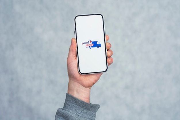 Express delivery in your phone. A man holds a smartphone with an icon on a white screen in his hands.