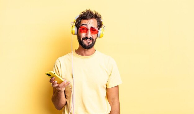 Expressieve gekke man die zich verdrietig en zeurt met een ongelukkige blik en huilt met een koptelefoon