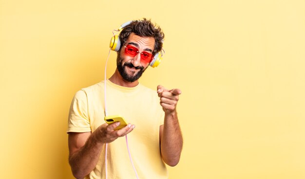 Expressieve gekke man wijzend op de camera die jou kiest met een koptelefoon