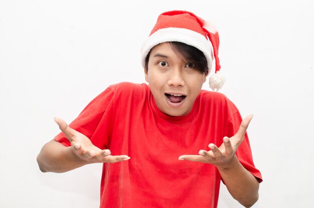 expressieve gelukkige jonge aziatische man in kerstsanta-themakleding met een geschokt, verrast gezicht
