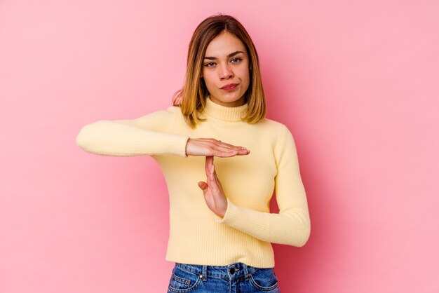 Expressieve jonge vrouw die zich voordeed op roze achtergrond