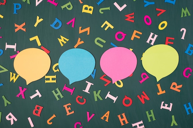 Photo expressing opinion concept. top above overhead view photo of four colorful thought bubbles isolated on greenboard with multicolored letters