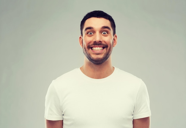 expression and people concept - man with funny face over gray background