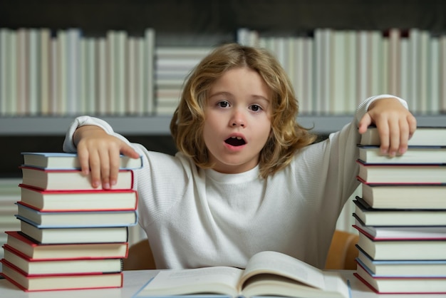 Выражение лица школьника с грудой книг день знаний мальчик делает домашнее задание на столе в школе л