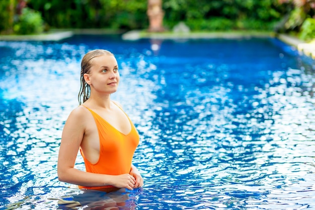 Expressive beautiful woman posing in the swimming pool