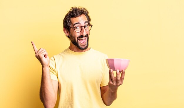 Expressive crazy man feeling like a happy and excited genius after realizing an idea and holding a pot