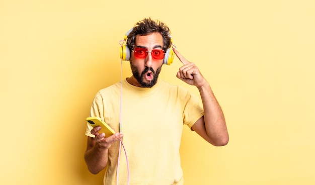 Expressive crazy man looking surprised, realizing a new thought, idea or concept with headphones