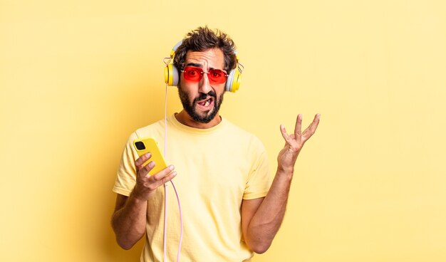 Expressive crazy man screaming with hands up in the air with headphones