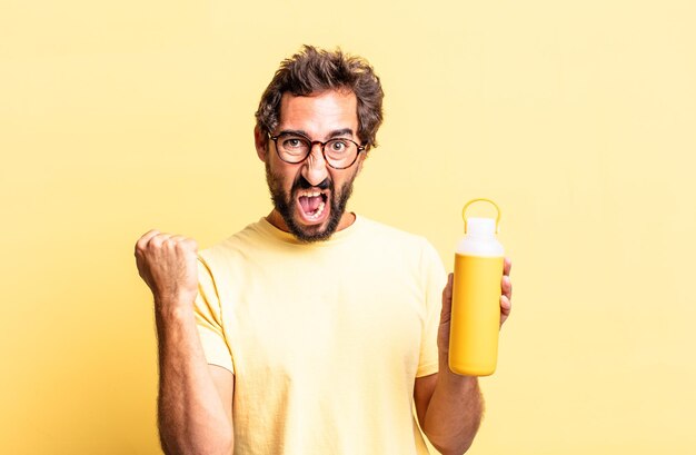 Expressive crazy man shouting aggressively with an angry expression with a tea thermos