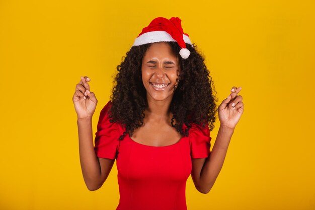 Expressive excited woman with santa hat on yellow background