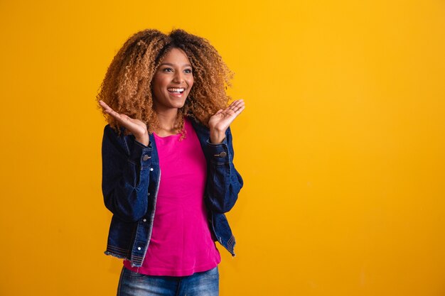 Expressive and smiling afro young man looking at camera with space for text