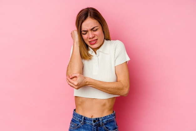 ピンクの背景にポーズをとって表現力豊かな若い女性