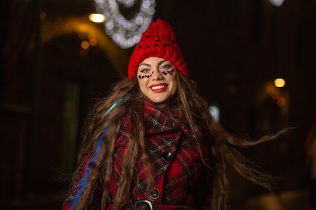 Expressive young woman with fluttering hair having fun at the Christmas fair