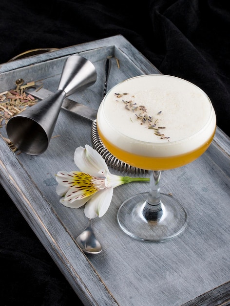 Exquise cocktail in een glas op een houten bord Donkere achtergrond Barman accessoires