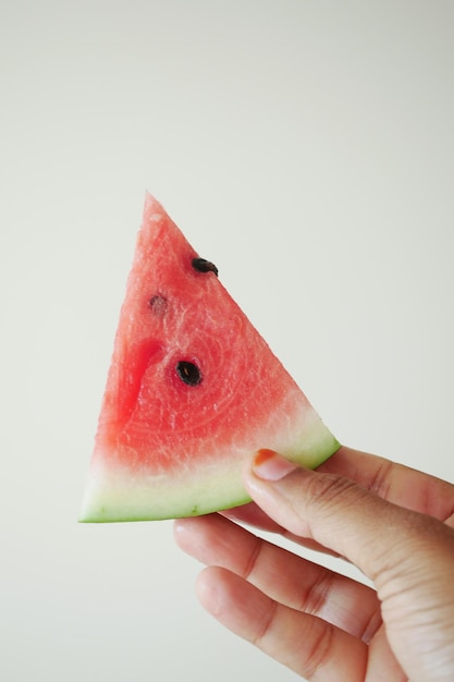 an exquisite fresh and juicy watermelon slice elegantly held by a hand