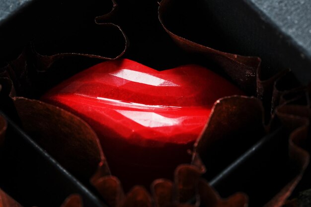 Exquisite handmade chocolate candy in the shape of red lips close-up Luxury handmade chocolate