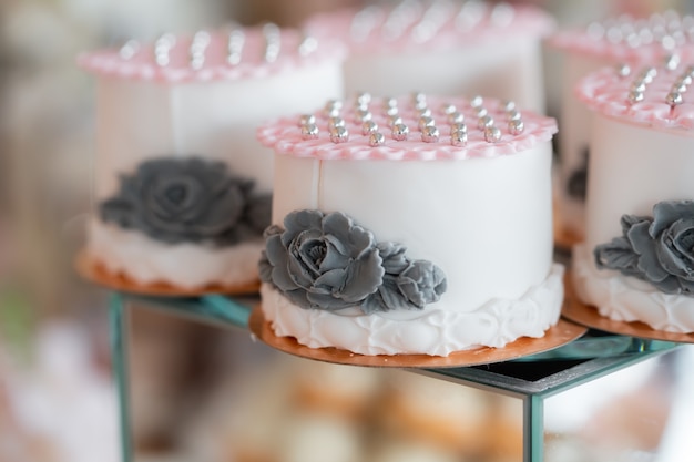 Exquisite wedding cake with pearls. Wedding dessert on a mirror cube