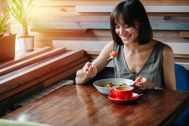 그녀의 포크에 있는 파이 조각을 보고 있는 지나치게 행복한 여자