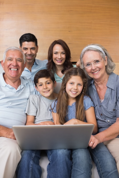 Extended family using laptop on sofa in living room