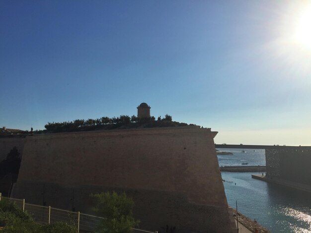 Foto esterno di un edificio sul fiume contro un cielo blu limpido