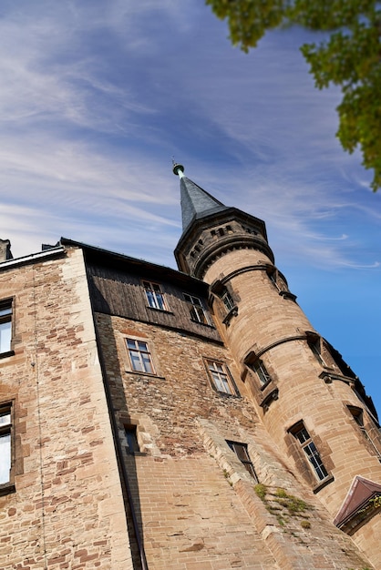 Exterior of a gothic victorian building in the style of england
gothic revival on a cloudy blue sky with copy space low
architecture detail of an historical church tower structure or
university