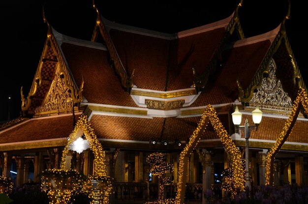 Photo exterior of illuminated historic temple at night