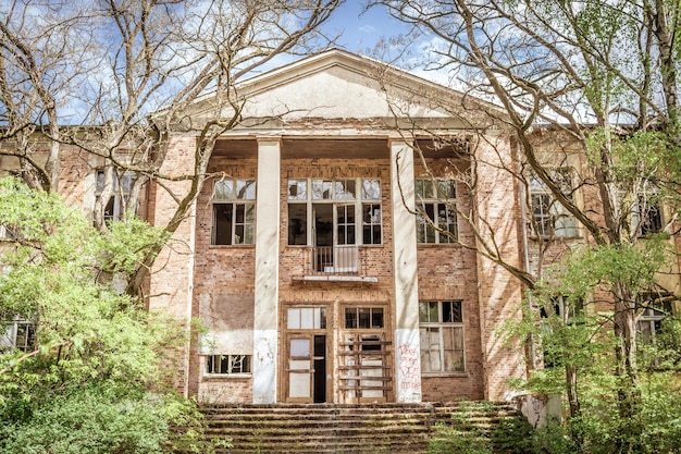 Photo exterior of old building by trees against sky