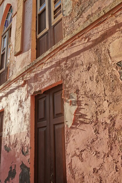 Exterior of an old building with peeling paint Architecture details of an ancient weathered rustic residential build with vintage wooden doors and windows in Santa Cruz de La Palma