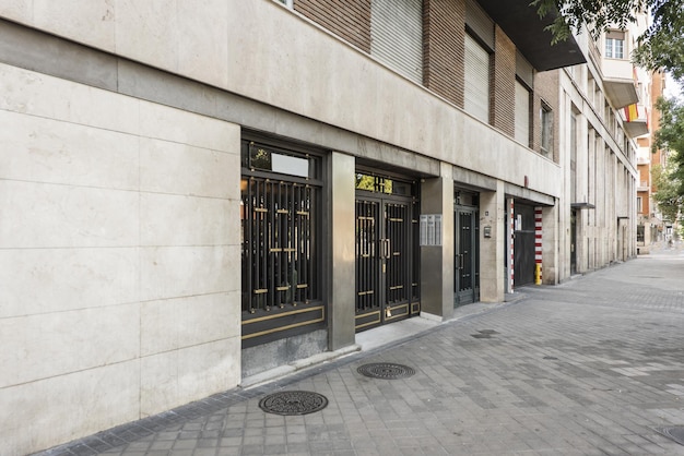 Exterior portal to the street of a simple residential building with painted metal doors and golden details